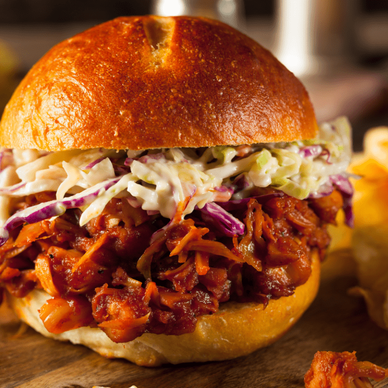 A pulled pork barbecue sandwich with coleslaw on a brioche bun.